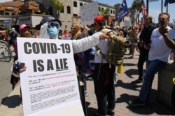 Protesters demonstrate against stay-at-home orders that were put in place due to the COVID-19 pandemic, in Huntington Beach, California, April 17, 2020.