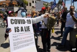 Protesters demonstrate against stay-at-home orders that were put in place due to the COVID-19 pandemic, in Huntington Beach, California, April 17, 2020.