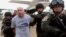 FILE - Joseph Hunter, second from left, a former U.S. Army sniper, was arrested in Bangkok, Thailand, Sept. 26, 2013. Hunter and two other American ex-soldiers were convicted Wednesday in the contract killing of a real estate agent in the Philippines for an international crime boss. 