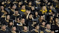 FILE - Students wait to be called for their degree during the University of Connecticut's Graduate School commencement ceremony.