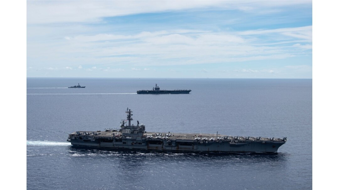 Dalam foto ini disediakan oleh US Navy, USS Ronald Reagan (CVN 76, depan) dan USS Nimitz (CVN 68, belakang) Carrier Strike Group berlayar bersama dalam formasi, di Laut Cina Selatan, Senin, 6 Juli 2020. (Foto : AP)