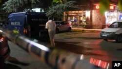 A police investigator inspects the scene of a shootout where unidentified assailants on Tuesday shot and wounded a journalist in Montenegro's capital, Podgorica, May 8, 2018. 