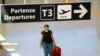 A passenger wearing a protective face mask walks at Fiumicino Airport 