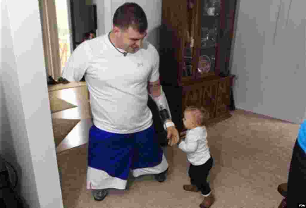 Serjant Travis Millis-in 1 yaşlı qızı Chloe Mills atasına toxunur.&nbsp; Şəkil Miçiqanın Vassar qəsəbəsində, veteranın uşaqlıq evində çəkilib. 4 oktyabr, 2012. Əsgər əllərini və ayaqlarını Əfqanıstan müharibəsində itirib.&nbsp; Foto: Carlos Osorio via NBC News.