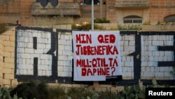 A protest banner reading "Who is benefitting from Daphne's murder?", referring to the assassination of anti-corruption journalist Daphne Caruana Galizia in October 2017, hangs over a tunnel entrance in St Julian's, Malta April 23, 2018. 