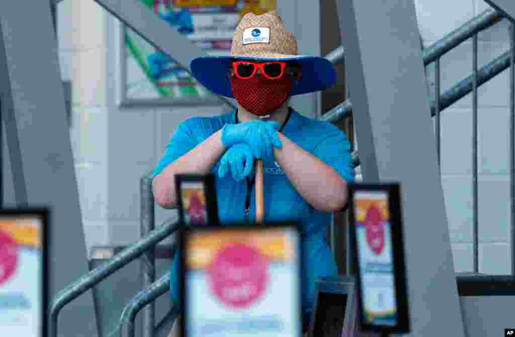 A worker stands ready to clean as waterparks reopened amid concerns of the spread of COVID-19, at the city-owned waterpark in Grand Prairie, Texas.