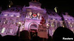 Des personnes participant à une veillée, près de l'Hôtel de ville de Montréal, pour rendre hommage aux victimes de l’attaque contre l’hebdomadaire satirique Charlie Hebdo à Paris, 7 janvier 2015.