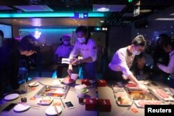 FILE - Waiters serve customers at a Haidilao hotpot restaurant in Beijing, China on October 11, 2021. (REUTERS/Tingshu Wang/File Photo)