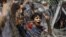 An Egyptian boy peers out of barbed wire during a protest in front of the Supreme Constitutional Court in Cairo, Egypt, Thursday June 14, 2012.