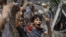 An Egyptian boy peers out of barbed wire during a protest in front of the Supreme Constitutional Court in Cairo, Egypt, Thursday June 14, 2012.