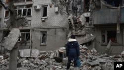 A woman stands among debris of the destroyed house after recent Russian air strike in Chasiv Yar, Ukraine, Nov. 27, 2022. 