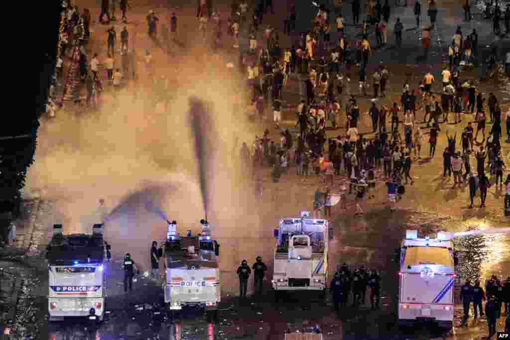 Polisi membubarkan masa dengan meriam air di Champs-Elysees, di Paris, setelah perayaan kemenangan Perancis di laga final Piala Dunia 2018, 15 Juli 2018.