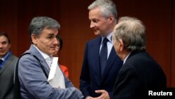 (L-R) Greek Finance Minister Euclid Tsakalotos, French Economy Minister Bruno Le Maire and Italy's Finance Minister Pier Carlo Padoan attend a eurozone finance ministers meeting in Brussels, May 22, 2017. 