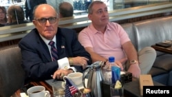 FILE - Rudy Giuliani is seen with Ukrainian-American businessman Lev Parnas at the Trump International Hotel in Washington, Sept. 20, 2019. Parnas has been arrested with another associate of Giuliani's, Igor Fruman, a Belarus-born U.S. citizen.