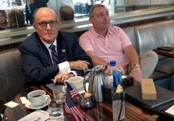 FILE - Rudy Giuliani is seen with Ukrainian-American businessman Lev Parnas at the Trump International Hotel in Washington, Sept. 20, 2019. Parnas has been arrested with another associate of Giuliani's, Igor Fruman, a Belarus-born U.S. citizen.