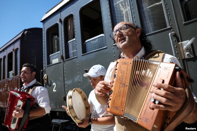 Musicians play music at the train station as part of the "Timeless Tracks" project in Palena, Italy July 21, 2024. (REUTERS/Antonio Denti)