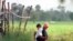 Two Cambodian boys fish on an empty drainage pipe at the natural irrigation canal in Kompong Speu province.