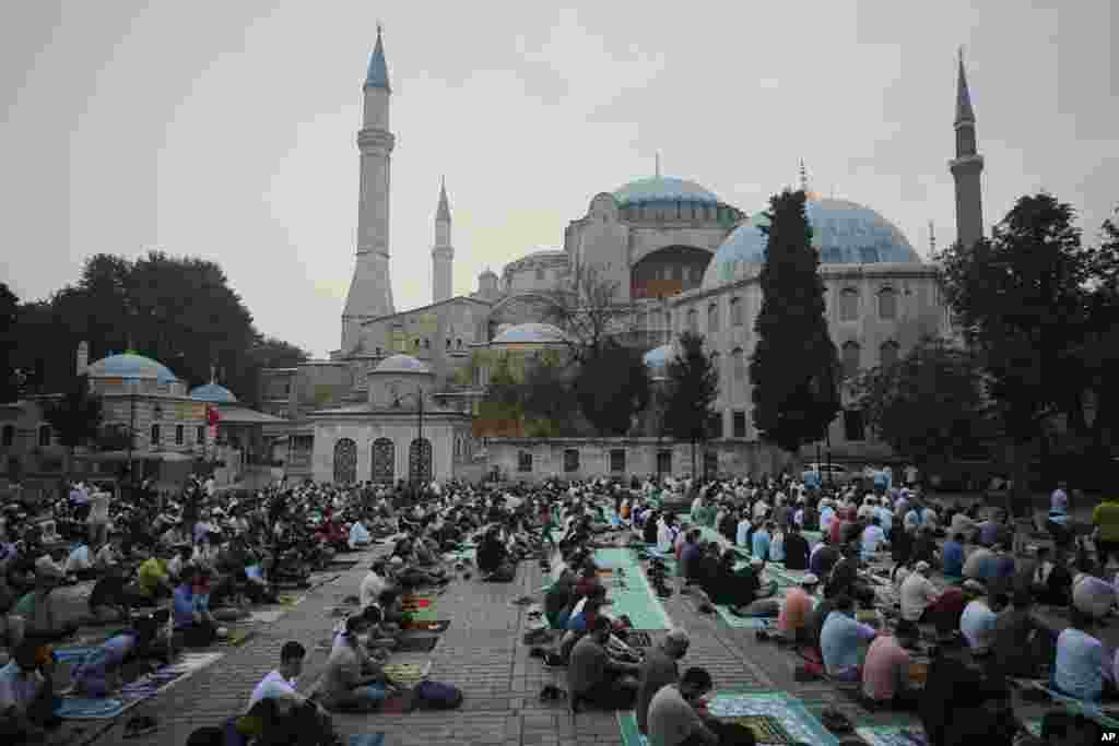 Warga Muslim melaksanakan salat Idul Adha, di luar Haghia Sophia, bangunan ikonik dari era Bizantium yang kini berfungsi menjadi masjid di distrik bersejarah Sultan Ahmed di Istanbul, Selasa, 20 Juli 2021. (Foto AP/Mucahid Yapici)