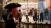 FILE - Chinese customers stroll past a clothing shop at Taikoo Li Sanlitun in Beijing, July, 30, 2024. Chinese economic policymakers are expected to on Oct. 8. to flesh out policies to boost growth.