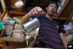 A man pours cooking oil at a market in Jakarta, Indonesia on April 17, 2022. . Costs for oil have gone up a great deal in the last two months. (AP Photo/Achmad Ibrahim)