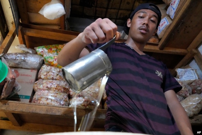 A man pours cooking oil at a market in Jakarta, Indonesia on April 17, 2022. . Costs for oil have gone up a great deal in the last two months. (AP Photo/Achmad Ibrahim)