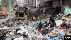 An excavator clears the rubble of a destroyed building in Gaza City's Rimal residential district on May 16, 2021, following massive Israeli bombardment on the Hamas-controlled enclave.