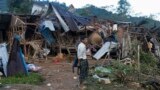 资料图片：一名男子正在缅甸莱扎查看一个流离失所者营地在空袭和炮击后被摧毁的房屋。（2023年10月10日）