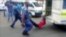 A South African man with his hands tethered to the back of a police vehicle being dragged behind as police hold his legs up and the vehicle apparently drives off, east of Johannesburg, Feb. 26, 2013. The man died of his injuries.