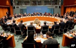 German Chancellor Angela Merkel, rear center, leads a conference on Libya at the chancellery in Berlin, Germany, Sunday, Jan. 19, 2020. (Kay Nietfeld/DPA via AP, Pool)