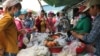 Garment factory workers wear face masks as they buy food on a lunch break near Propitious (Cambodia) Garment Ltd factory, in Kandal province, Cambodia, March 20, 2020. (Kann Vicheika/VOA Khmer) 