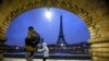 ARCHIVO - La Torre Eiffel vuelve a recibir visitantes después de varios días de cierre por reclamos del sindicato de trabajadores. En la imagen, un niño y su cuidador caminan con la mayor atracción francesa de fondo, el 18 de enero de 2024, después de una nevada.