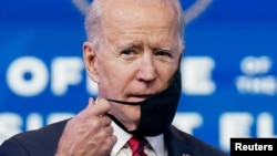 U.S. President-elect Joe Biden adjusts his face mask as he speaks about his plan to administer coronavirus disease vaccines to the U.S. population, during a news conference at Biden's transition headquarters in Wilmington, Del., Jan. 15, 2021.
