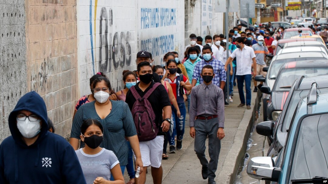 Los votantes se alinean afuera de una mesa de votación durante las elecciones presidenciales y legislativas en Guayaquil, Ecuador, el domingo 7 de febrero de 2021.