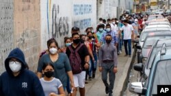 Los votantes se alinean afuera de una mesa de votación durante las elecciones presidenciales y legislativas en Guayaquil, Ecuador, el domingo 7 de febrero de 2021.