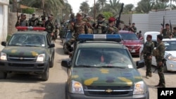 Iraqi police and soldiers parade in the city of Ramadi, the capital of Iraq's Anbar province, west of Baghdad on March 29, 2014 after they reportedly seized vehicles from militant fighters.