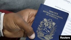 FILE -- A Venezuelan migrant holds his passport at a queue to get a temporary residency permit outside the immigration office in Lima, Peru, Aug. 20, 2018. 