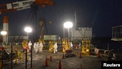 Para pekerja mengenakan pakaian pengaman dan masker saat berupaya memperbaiki kebocoran di dekat reaktor No.1 dan No.2 di PLTN Fukushima (Foto: dok).