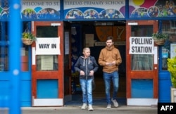 Para pemilih meninggalkan tempat pemungutan suara di Sekolah Dasar St Teresa di Belfast, Inggris, 4 Juli 2024. (Paul Faith / AFP)