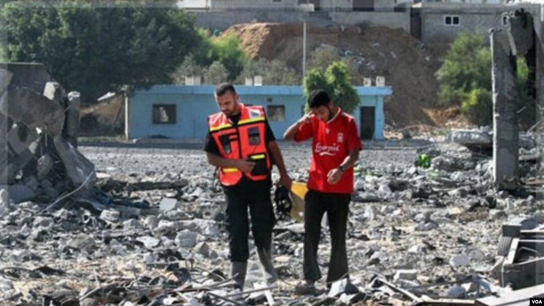Warga Palestina sedang memeriksa kerusakan yang timbul di tempat pelatihan Hamas setelah serangan udara Israel di Gaza (21/8).