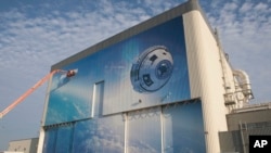This Sept. 4, 2015 photo made available by NASA shows a mural depicting Boeing's newly named CST-100 Starliner commercial crew transportation spacecraft on the company's Commercial Crew and Cargo Processing Facility at NASA's Kennedy Space Center in Florida.