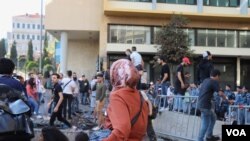 Protesters climb the barricades blocking off the government area of downtown Beirut, Nov. 19, 2019. (Heather Murdock/VOA) 