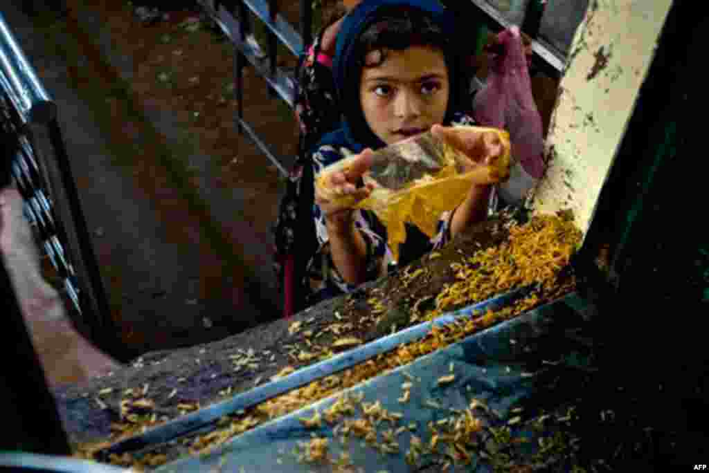 A Pakistani girl receives free food from a food distribution point at the shrine of Bari Imam on World Food Day in Islamabad, Pakistan on Oct. 16, 2010. According to World Food Program report, almost half the population of Pakistan faces difficulty gainin