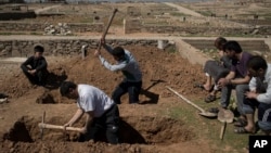Keluarga dan teman-teman menggali kuburan dua warga sipil yang terbunuh selama pertempuran antara pasukan keamanan Irak dan militan Islamic State di sisi barat Mosul, Irak, tangal 25 Maret 2017 (foto: AP Photo/Felipe Dana)