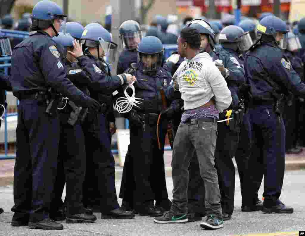 Polisi menahan seorang pria setelah berbaris menuju balai kota untuk Freddie Gray di Baltimore (25/4).&nbsp;​(AP/Alex Brandon)