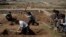 Relatives and friends dig the graves of two civilians killed during fighting between Iraqi security forces and Islamic State militants on the western side of Mosul, Iraq, March 25, 2017.