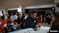 FILE - People deported from the U.S. wait to make a phone call to the U.S. at an immigration facility in San Salvador, El Salvador, July 3, 2018.