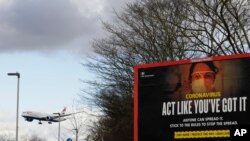 FILE - A plane comes in to land near a government coronavirus sign at Heathrow Airport in London, Britain, Feb. 5, 2021.