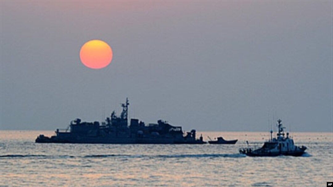 Sebuah kapal Korea Selatan yang dioperasikan Angkatan Laut (kanan) berlayar dekat pulau Yeonpyeong yang dikuasai negara itu dekat perairan Laut Kuning yang dipersengketakan.