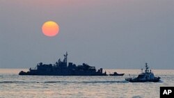 Sebuah kapal Korea Selatan yang dioperasikan Angkatan Laut (kanan) berlayar dekat pulau Yeonpyeong yang dikuasai negara itu dekat perairan Laut Kuning yang dipersengketakan.