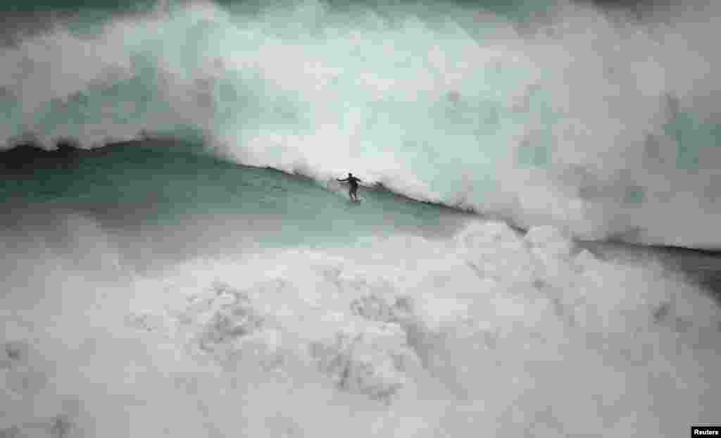 Big-wave surfer Garrett McNamara of the U.S. drops in on a large wave at Praia do Norte in Nazare, Portugal, Nov. 1, 2013. 